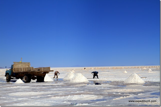 Le sel est mis en tas afin que l'eau s'en écoule par gravité, puis il est chargé à la pelle sur les camions. (Salar d'Uyuni, Bolivie)